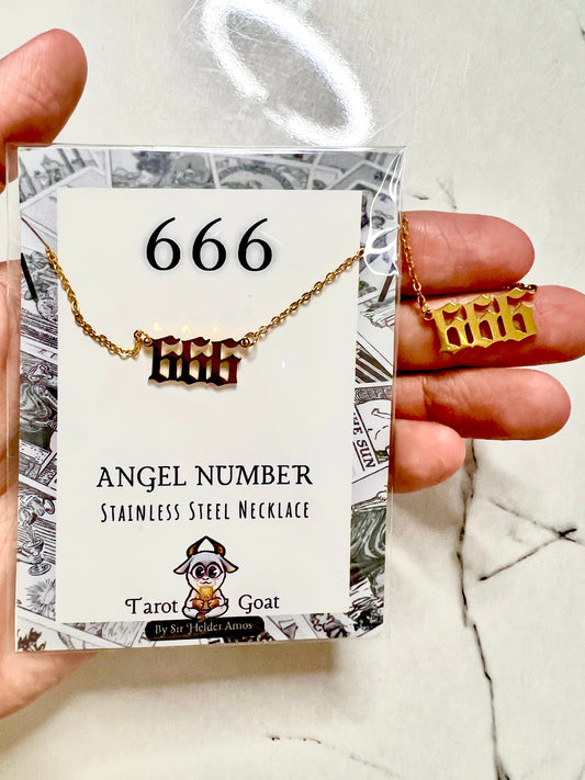A hand holds a gold and stainless steel '666' angel number necklace on a branded display card. The card reads '666 ANGEL NUMBER STAINLESS STEEL NECKLACE' and shows the Tarot Goat brand logo.
