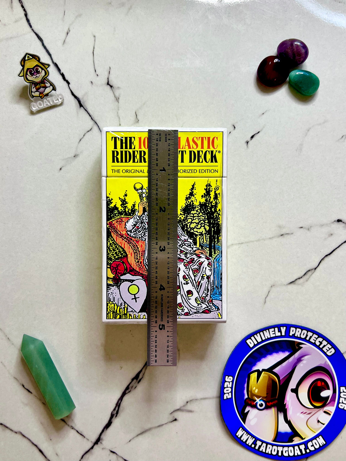 A full tarot cards, deck being measured by a ruler on a marble table with crystals for a ritual