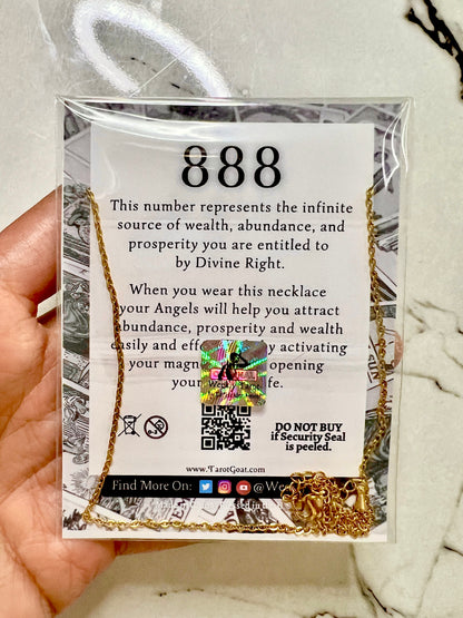 A hand holds a gold necklace on a branded card insert. The necklace has 888 pendant with '888' printed on the backing card, which references Divine Right and wealth and prosperity.