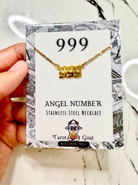 A hand holding a perfect gift idea for women with the number 999 stainless steelm necklace pendant from the brand tarot goat