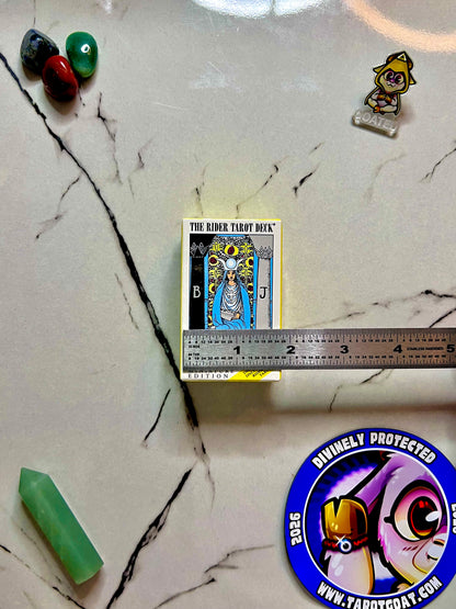 A tarot deck with the high priestess on the box and a ruler on top o it showing how small it is under 2 inches 