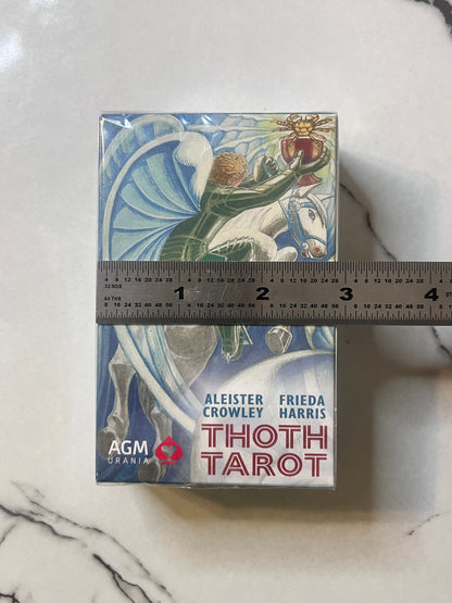 AGM Thoth Tarot deck box with a ruler placed horizontally across the middle to show the deck's height, photographed on a white marble surface.